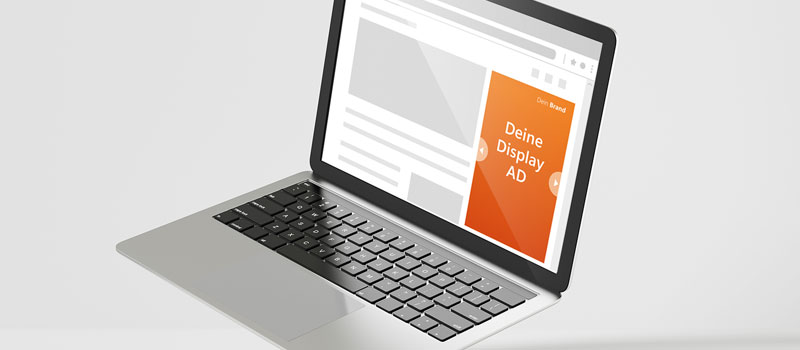 Ein aufgeklappter Laptop auf dessen Display ein neutrales Layout einer Webseite zu sehen ist und in dem mit einem orange vorgehobenen Rechteck die Position einer Display Ad dargestellt wird.