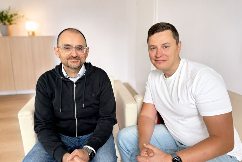 Foto von Corc Uysal und Felix Ruisinger die im hellen Büro zusammen sitzen.
