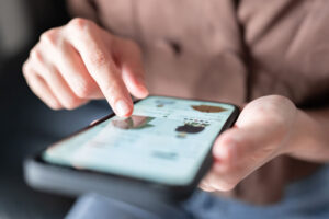 Frau, zuhause beim Online-Shopping von Mode und Kleidung auf dem Smartphone.