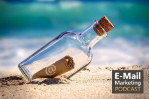 Foto von einer Flaschenpost am die am Strand liegt. Auf dem Zettel in der Flasche ist ein @-Symbol das für E-Mail-Marketign steht.